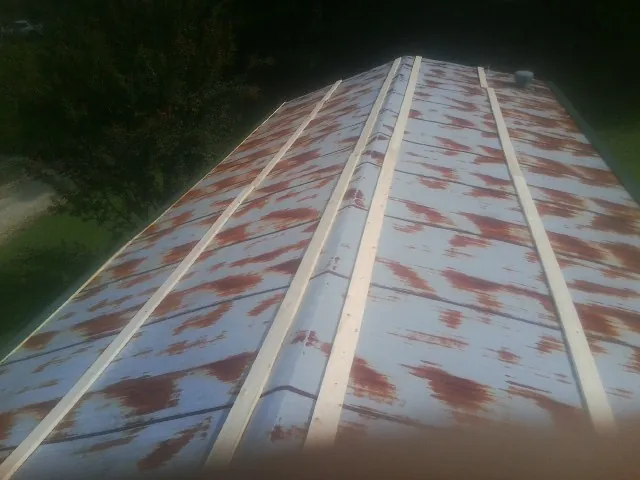Rusted metal roof panels with new wood purlins before replacement — Storm Damage Roof Repair in Evensville by Roofing Brothers