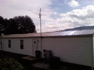 New metal roof on a single wide mobile home with a TV antenna in Evensville