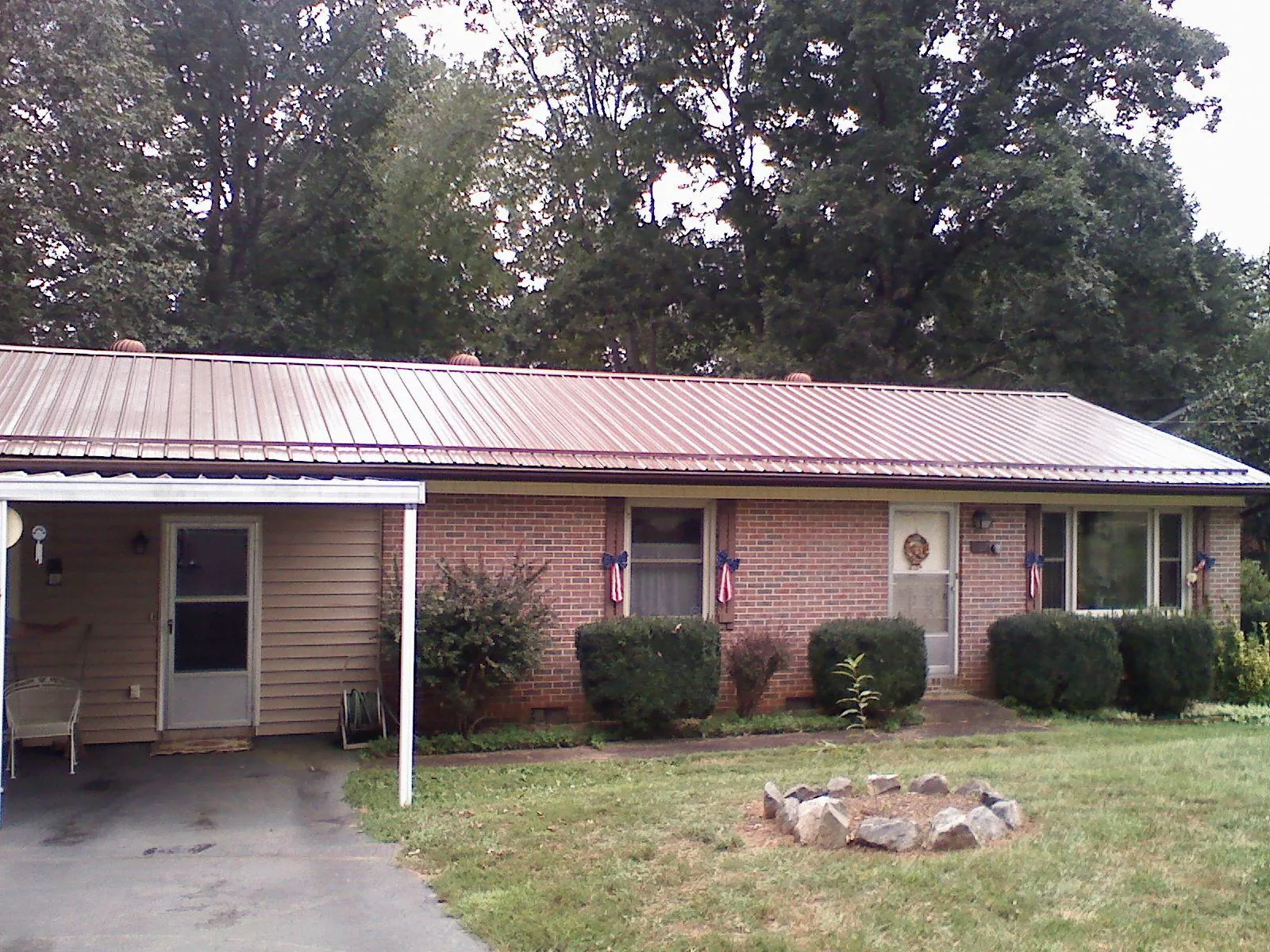 Bronze metal roof and carport on a brick ranch home — Roof Repair work by our crew in Evensville
